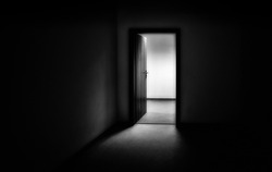 Light entering through open doors in dark room. Black and white