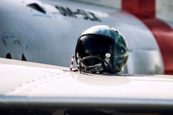 FIghter pilot helmet on wing of fighter jet.