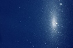 Snow blizzard texture , weather conditions with cold wind and snow, winter wind with snow on blue sky background, extreme weather conditions. Glitter and snow in the rays of light