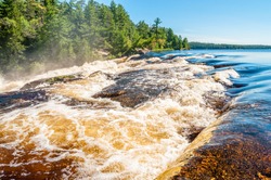Rushing white water flows rapidly down Curtain Falls in a remote area of Minnesota known as the Boundary Waters Canoe area, bordering Quetico National Park in Canada. 
