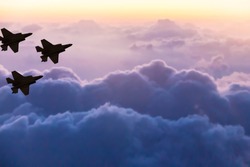 Silhouettes of three F-35 aircraft on sunset sky background