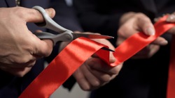 Business people hands cutting red ribbon close-up, new project, opening ceremony, stock footage