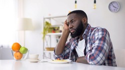 African-American man having no appetite, eating disorder, depression problem