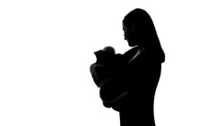 Woman holding baby doll as her own child, sadness for lost new-born, abortion