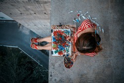 Young impressionist painting her masterpiece at the rooftop. Inspiration concept. Artist. Modern art