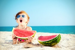 Happy child on the sea with watermelon