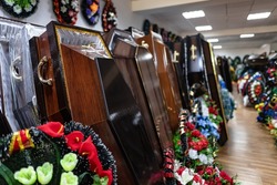 Inside the funeral service store are wooden coffins and wreaths with sparkling flowers