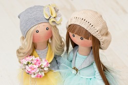 Two handmade rag dolls with natural hair - blonde and brown-haired, in knitted hats