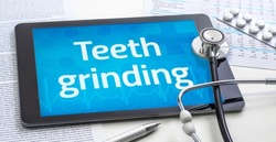 The word Teeth grinding on the display of a tablet