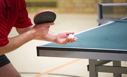 table tennis player doing a serve, close-up