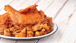 fried chicken and fried chicken skin in ceramic plate on white old wood texture background with copy space for text