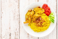 Khao Mok Gai, Thai Muslim version of Indian Biryani, fragrant yellow rice with chicken in white ceramic plate on white old wood texture background, top view, Chicken Biryani, Biriani, Beriani