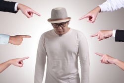 Sad anxious Asian man judged by different hands. Concept of accusation of guilty person, bully harrasment concept