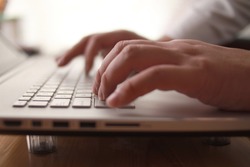 Close up of person hand typing on laptop keyboard, author writing on pc computer, businessman programmer working concept