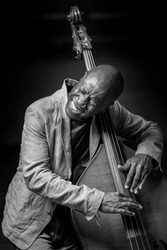 Double bass concert player on black background