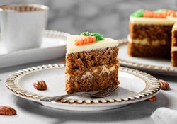 Carrot layered cake with cream cheese frosting decorated with carrots.