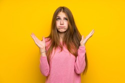 Young woman with long hair over isolated yellow wall frustrated by a bad situation