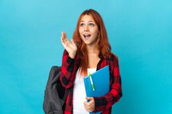 Teenager student Russian girl isolated on blue background with surprise facial expression