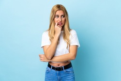 Young Uruguayan blonde woman over isolated blue background nervous and scared
