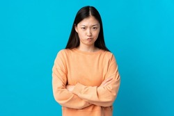 Young Chinese girl over isolated blue background feeling upset