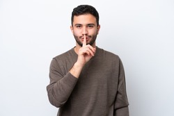 Young Brazilian man isolated on white background showing a sign of silence gesture putting finger in mouth