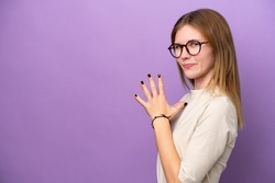 Young English woman isolated on purple background scheming something