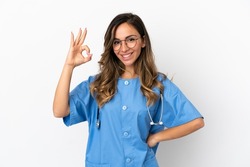 Young surgeon doctor woman over isolated white wall showing ok sign with fingers