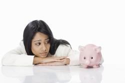 Businesswoman looking at a piggy bank