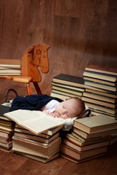 A little baby with many books and wooden horse