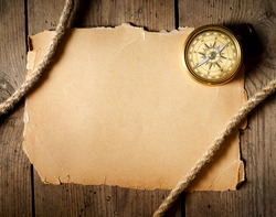 Old compass and rope on old paper. Vintage background. Adventure stories background