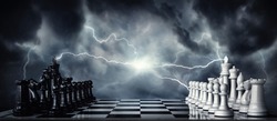 Chess pieces on a chessboard against the background of a dark stormy sky. Game of chess as symbol of strategy, leadership and business victories. Concept on the topic of struggle, clashes in politics.