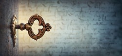 An old key in a keyhole on the background of an ancient manuscript, macro photography. Retro style. The key to knowledge. Concept and idea for history, education, religion, security background.