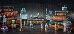 Glass bottles, old books on table of a scientist. Medicine, chemistry, pharmacy, apothecary, alchemy history background. Translation from labels-eyewash astringent, morphine hydrochloride and almonds.