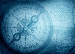 Old compass on vintage map. Pirate and nautical theme grunge background.