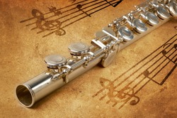 Silver flute on an ancient musical background
