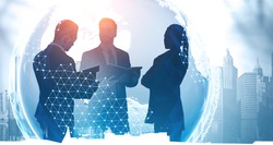 Silhouettes of business people working together in city with double exposure of blur planet hologram. International business partnership concept. Toned image. Elements of this image furnished by NASA