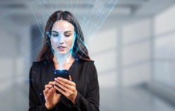 Businesswoman with phone in hands, biometric verification and face detection. Unlocking smartphone with facial scanner. Concept of face id and high tech technology
