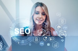Businesswoman is working on laptop with digital interface with seo, search engine optimization. Concept of modern technology of website analysis, keywording, content, ranking and social media