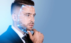 Serious handsome businessman touching chin with facial recognition by digital interface with line connection hologram. Concept of modern technology of artificial intelligence biometric scanning