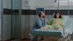Woman with pregnancy and painful contractions in hospital ward asking for help from doctor or nurse. Nervous caucasian man overreacting about childbirth delivery agony and screaming