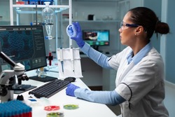 Biologist researcher woman looking at fungi colony using medical petri dish working at genetic disease experiment in biochemistry hospital laboratory. Scientist doctor examining microorganism sample