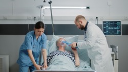 Sick woman hyperventilating and asking about medical assistance while doctor and nurse rushing to help with respiratory problem. Specialists using oxygen tube and oximeter for patient