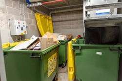 recycling bins and garbage chute disposal room in apartment buil