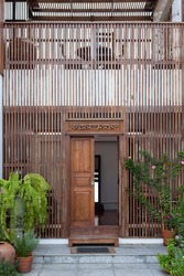 Wooden slats is wallpaper in  front door and green tree leaf .design of Thailand local house. 