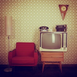 Vintage room with wallpaper, old fashioned armchair, retro tv, phone, clocks, radio player and standart lamp