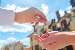 the seller transfers key to the house in the hands of the buyer outdoors
