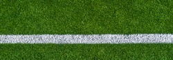 Green synthetic grass sports field with white line shot from above. Sports background for product display, banner, or mockup