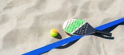 Racket and ball on the sandy beach. Summer sport concept