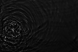 Water black surface abstract background. Waves and ripples texture of cosmetic aqua moisturizer with bubbles