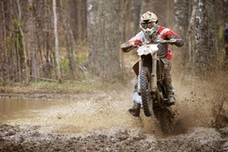 Motocross racer on wet and muddy terrain in Finland